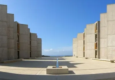 a fountain surrounded by concrete buildings on the Salk campus
